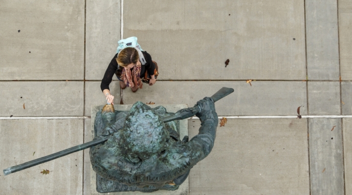 a student rubs the toe of the Daniel Boone statue for good luck